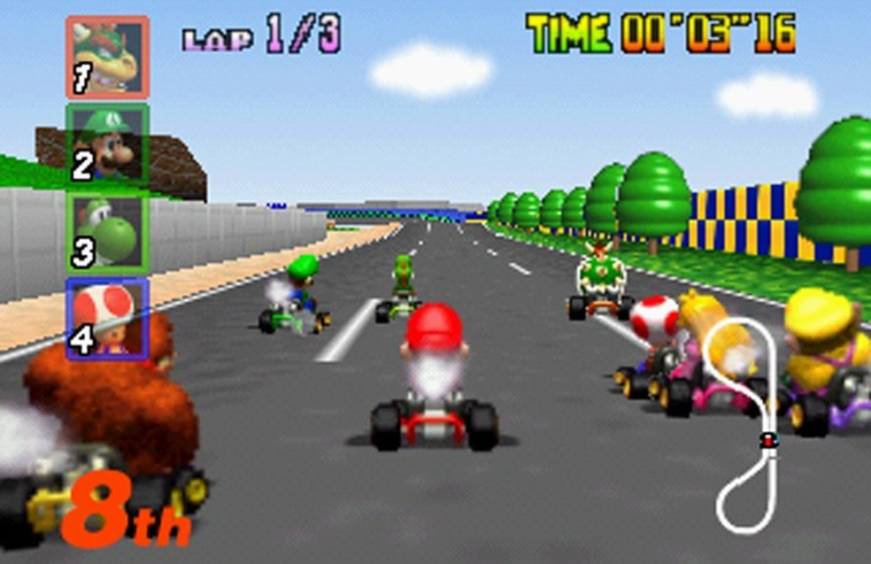 Eight racers accelerating from the starting grid on Luigi Raceway in Mario Kart 64