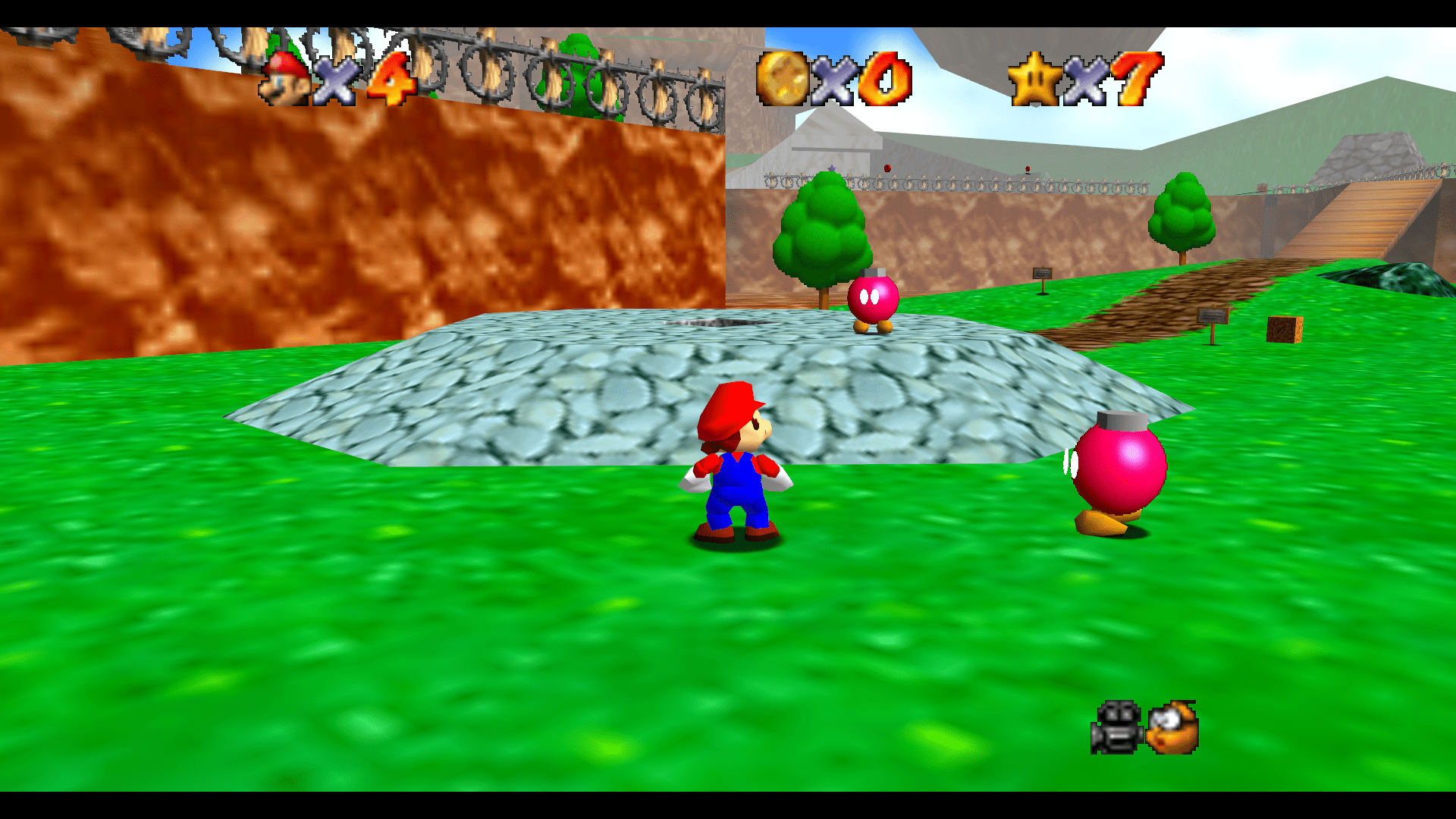Mario facing a Bob-omb near the cannon and mountain path in Super Mario 64